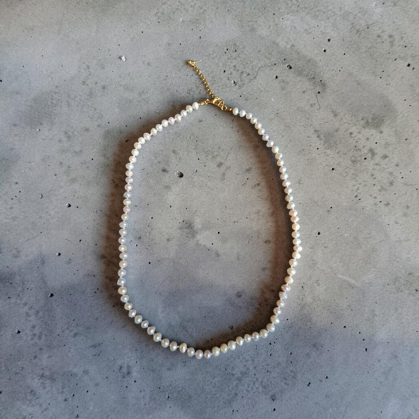 Collar de perla natural pequeña con herrajes bañados en oro