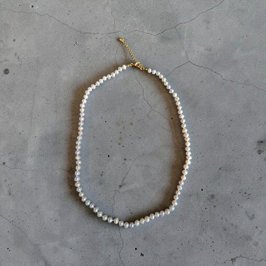 Collar de perla natural pequeña con herrajes bañados en oro